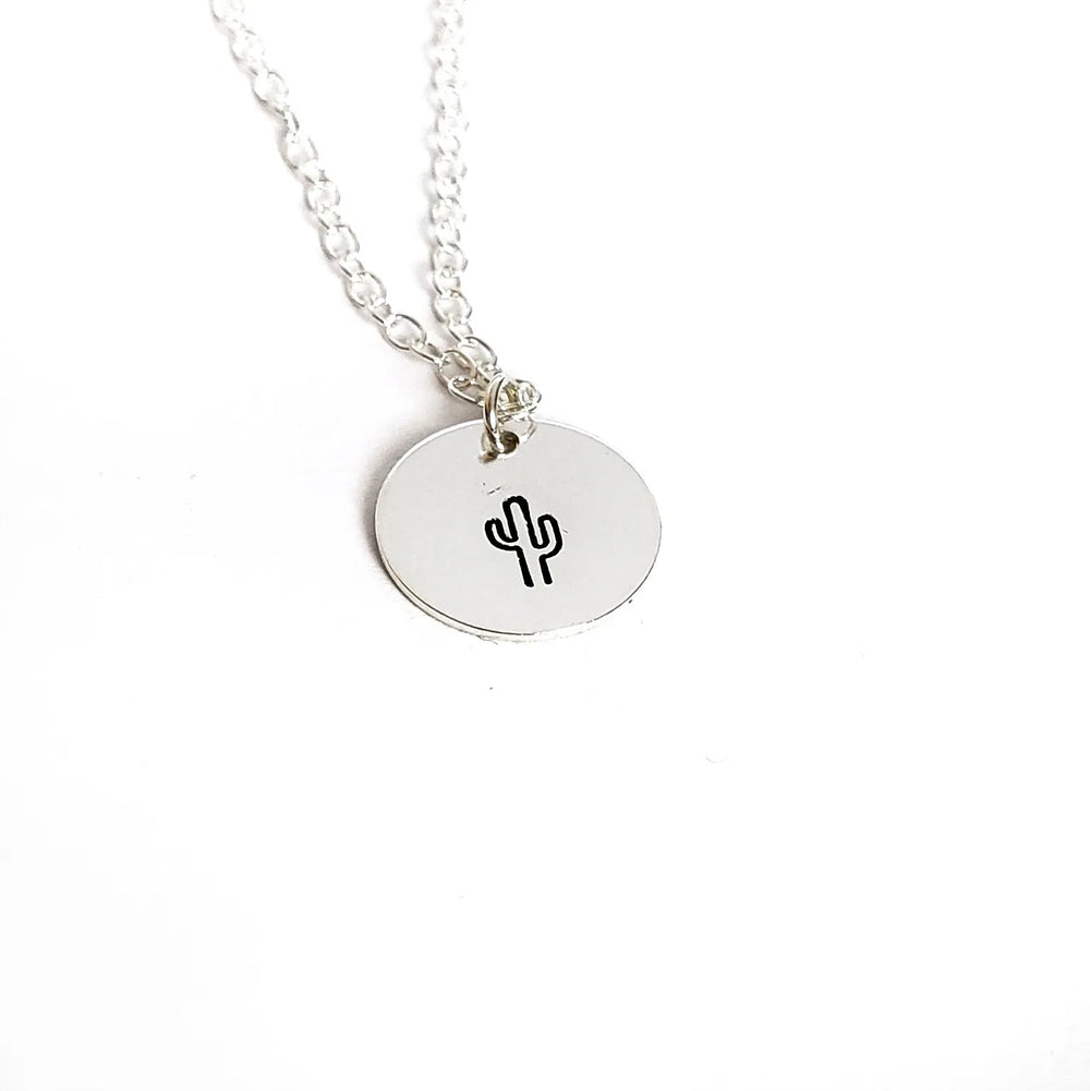 Silver necklace with a round pendant featuring a cactus design on a white background