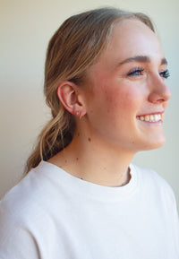 Woman wearing gold bead twist earrings