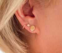Woman wearing gold circle studs with twist studs