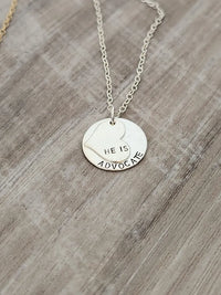 Silver necklace with a round pendant on a wooden surface