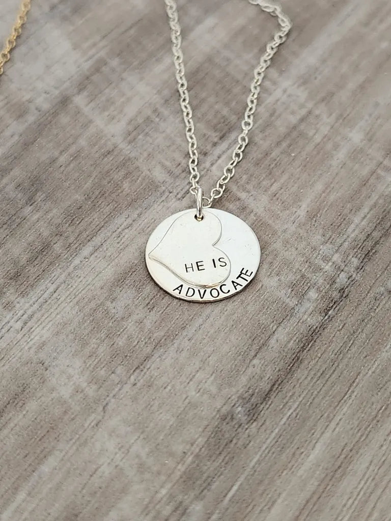 Silver necklace with a round pendant on a wooden surface