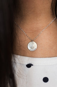 Silver necklace with a pendant on a person's neck