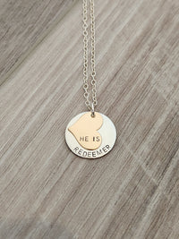 Necklace with heart-shaped pendant and engraved text on a wooden surface