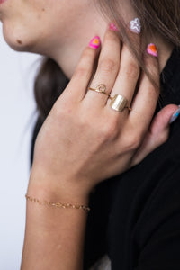 Hand up by face with rings on fingers