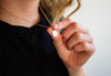 Woman holding necklace with round pendant
