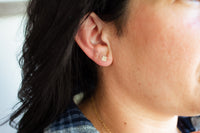 Square stud earring being worn
