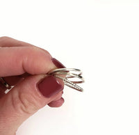 Hand holding a set of silver rings against a white background